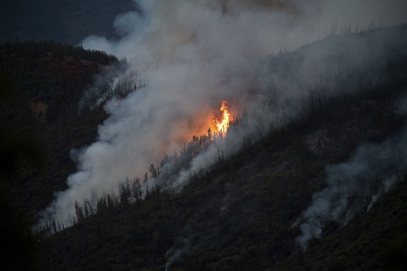 Flames from the Ferguson Fire burn down a hillside in unincorporated Mariposa County Calif., near Yosemite National Park on Sunday, July 15, 2018. (AP Photo/Noah Berger)

