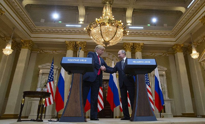 President Donald Trump and Russian President Vladimir Putin shake hands during a joint news conference at the Presidential Palace on Monday in Helsinki.  