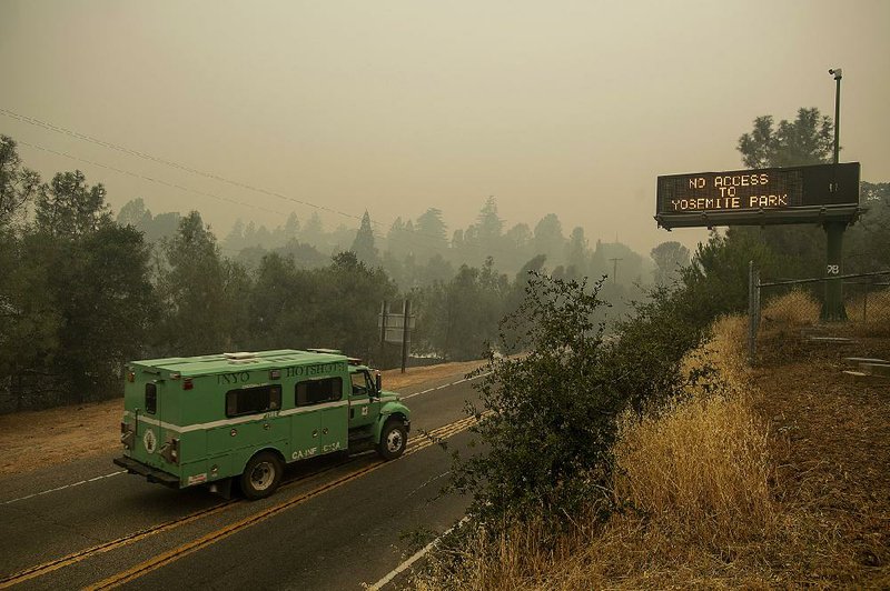 A fire transport travels along California 140, one of the entrances to Yosemite National Park, on Monday in Mariposa, Calif. The road remains closed to visitors as crews battle a deadly wildfire burning near the west end of Yosemite National Park. 