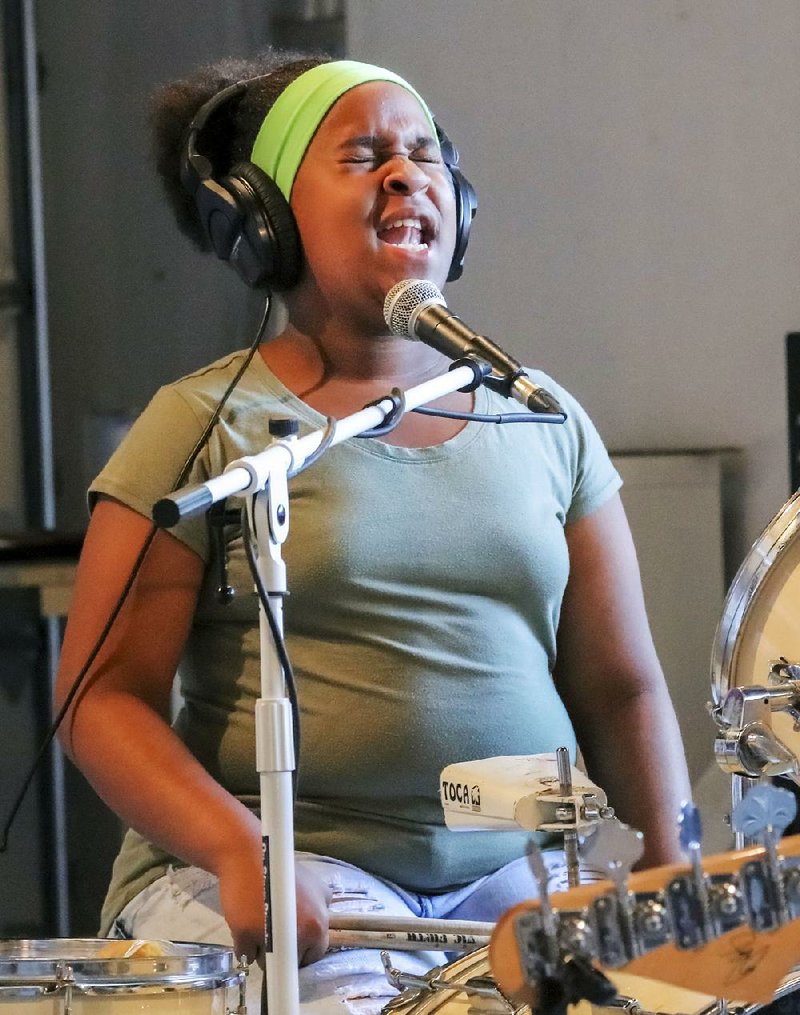Trust Tree songwriting and recording camp participant Samiyah Hervey of Little Rock sings while playing drums during a recording session at Capitol View Studio.  