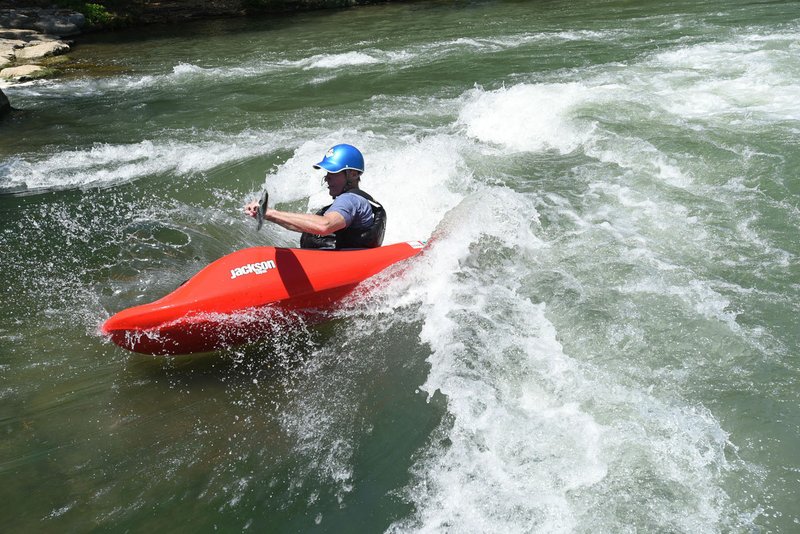 NWA Democrat-Gazette/FLIP PUTTHOFF Alan Kearney of Bella Vista rides the waves in June at the Siloam Springs Kayak Park on the Illinois River. The free park offers white water for paddlers to test their skills, plus calm water for swimming.