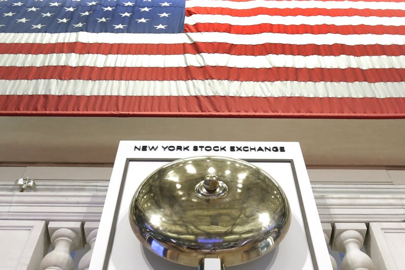  In this May 17, 2018, file photo, an American flag hangs above the bell podium on the floor of the New York Stock Exchange.  (AP Photo/Richard Drew, File)