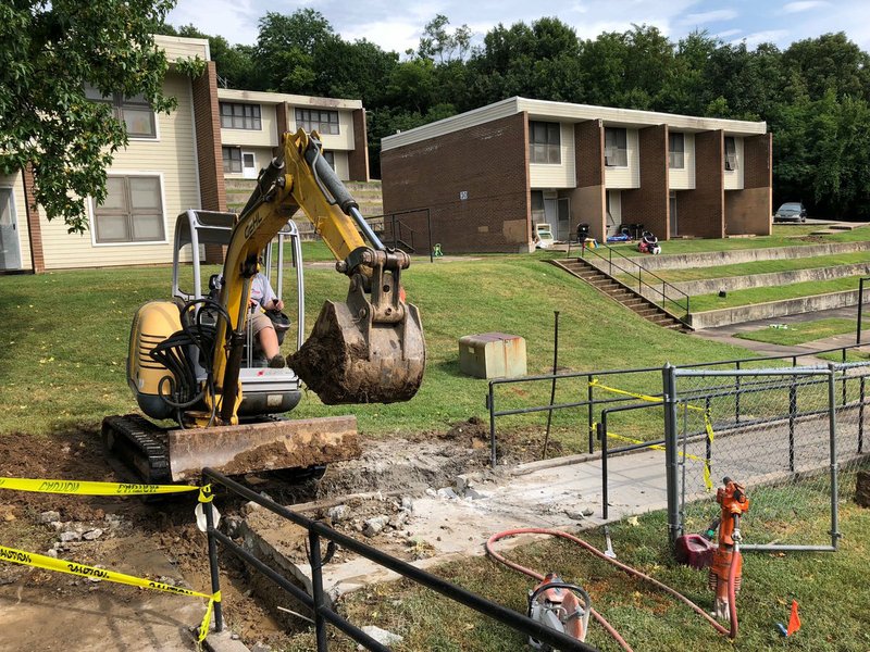 NWA Democrat-Gazette/STACY RYBURN Plumbing crews work Monday to repair a broken water line at Willow Heights, 10 S. Willow Ave., in Fayetteville.