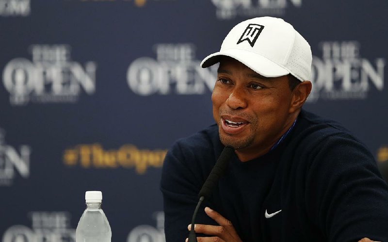 Tiger Woods of the United States smiles as answers a question at a press conference for the 147th British Open Golf championships in Carnoustie, Scotland, Tuesday, July 17, 2018. The Opens Golf championships start Thursday. 