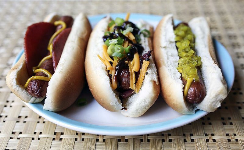 Assorted hog dogs (from left) a Baltimore-style hot dog, Memphis-style hot dog and a dog topped with pickle relish and mustard.  
