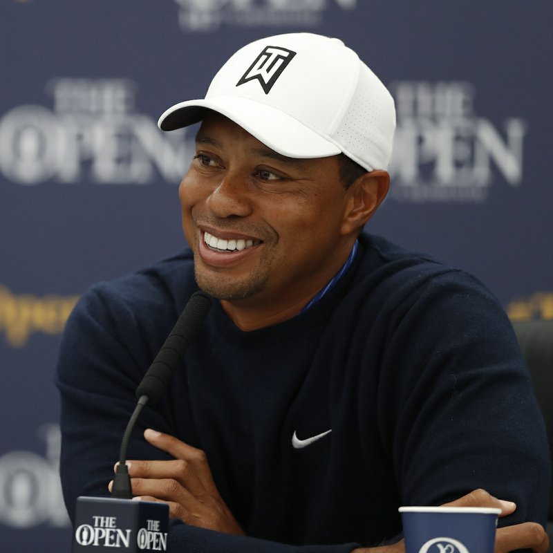 Tiger Woods of the United States smiles as answers a question at a press conference for the 147th British Open Golf championships in Carnoustie, Scotland, Tuesday, July 17, 2018. The Opens Golf championships start Thursday. (AP Photo/Alastair Grant)