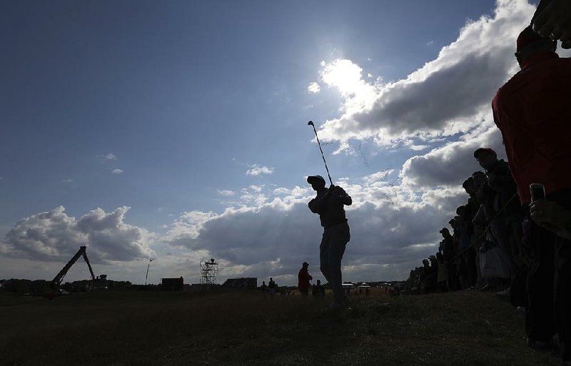 Tiger Woods plays from the rough on the 14th hole at Carnoustie on Wednesday during a practice round of the British Open. Woods said he doesn’t plan to use his driver often because of how far the ball is rolling across tight links grass that looks dead. 