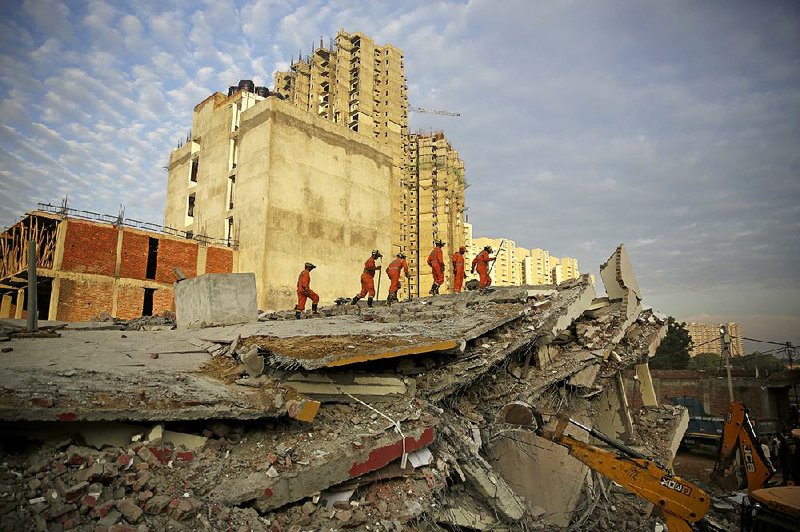 Rescuers search for survivors Wednesday in a collapsed building east of New Delhi. 