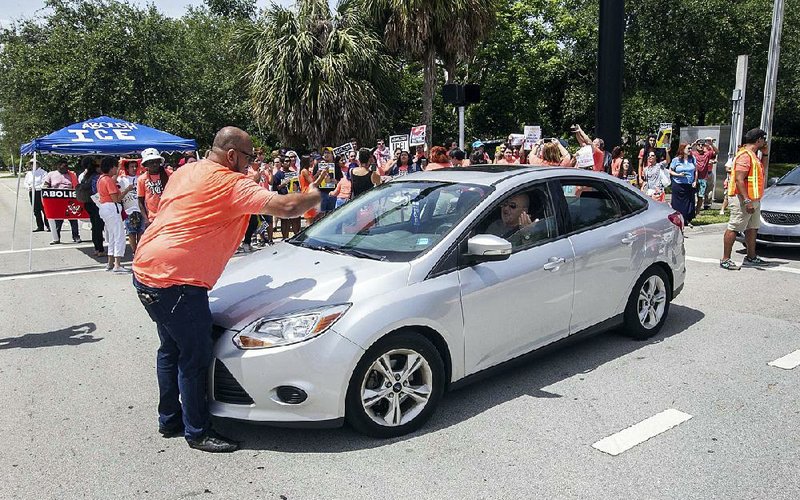 Demonstrators block vehicles Wednesday outside a U.S. Immigration and Customs Enforcement office in Miramar, Fla., during a protest that called for abolishing the federal agency.  