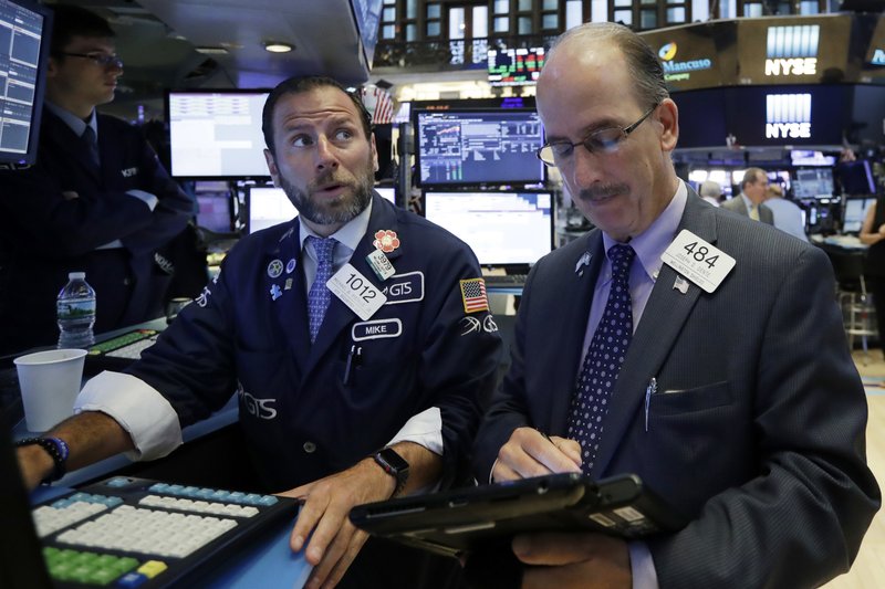 Specialist Michael Pistillo, left, works with trader Joseph Dente on the floor of the New York Stock Exchange, Wednesday, July 18, 2018. Stocks are off to a mixed start as gains by industrial and financial companies are offset by energy and technology companies. (AP Photo/Richard Drew)