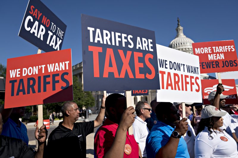 Autoworkers hold signs during a news conference in Washington on July 19, 2018. 