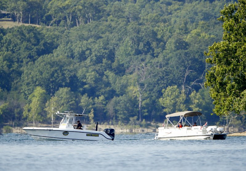 Emergency workers patrol an area Friday, July 20, 2018, near where a duck boat capsized the night before resulting in at least 13 deaths on Table Rock Lake in Branson, Mo. Workers were still searching for four people on the boat that were unaccounted for. (AP Photo/Charlie Riedel)