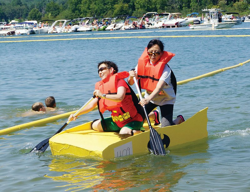 Terry Coughlin, left, and Bonnie Jeffcoat dip their oars to propel their Batwoman-themed Yellow Submarine to an exhausting finish during the 2017 World Championship Cardboard Boat Races.
