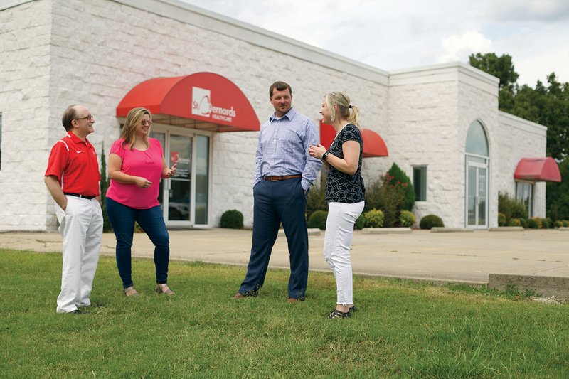 Highland School District Superintendent Don Sharp, from left; Kasey Carter, director of public relations for the district; John Sinclair, director of human resources and transportation coordinator; and Kelly Goodson, coordinator of federal programs/curriculum specialist, talk in front of the medical clinic the school district is buying to create a school-based health clinic. Carter and Goodson wrote the application for the state Department of Education grant for the district, which it received — $540,000 spread over five years — to operate the clinic. The school is partnering with St. Bernards Healthcare