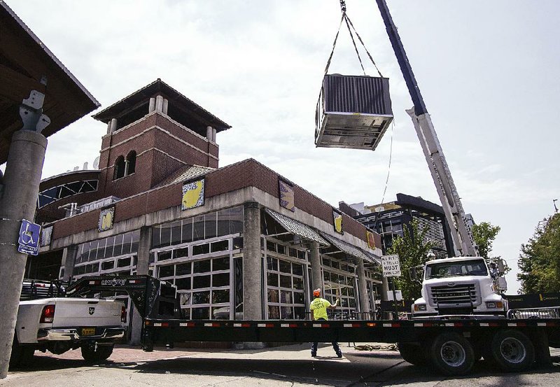 Workers install an air-conditioning unit Friday at the Ottenheimer Market Hall in downtown Little Rock.  
