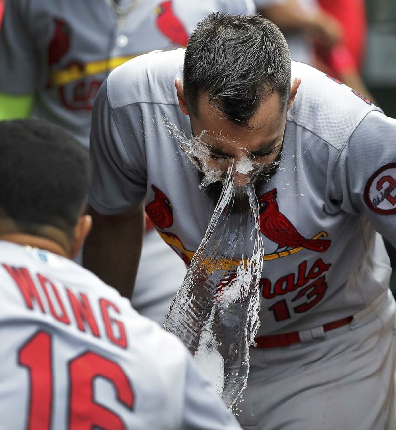 Matt Carpenter of the St. Louis Cardinals has ice water tossed in his face by teammate Kolten Wong after hitting his third home run Friday during the Cardinals’ 18-5 victory over the Chicago Cubs. 