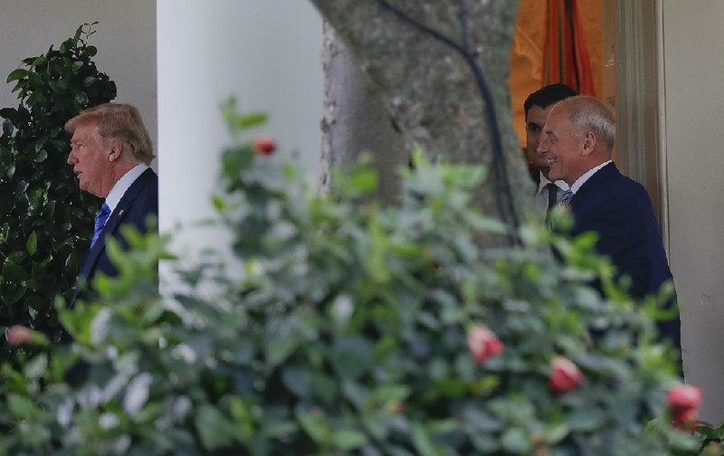 White House chief of staff John Kelly (right) watches as President Donald Trump leaves the Oval Office on Friday to head off for the weekend to Bedminster, N.J. 
