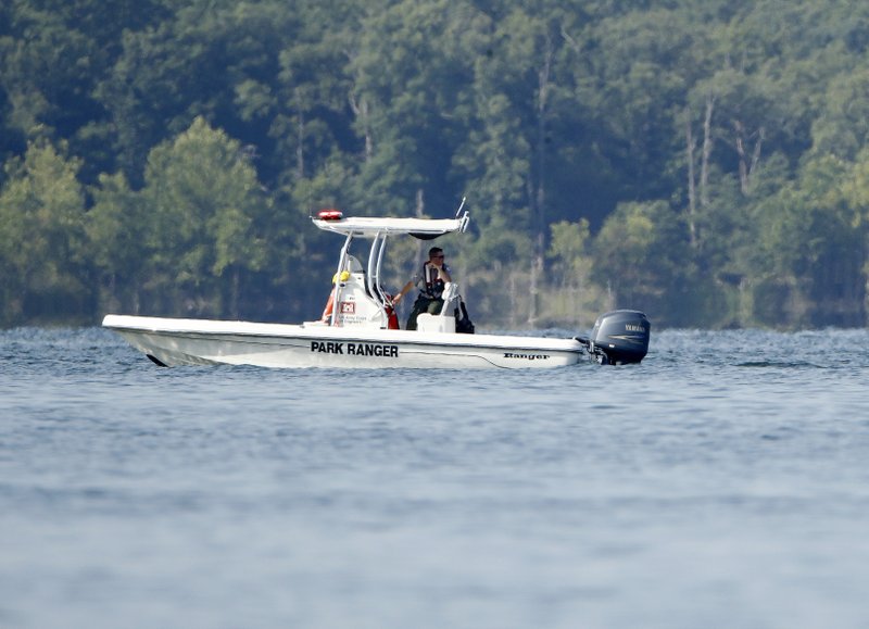 A park ranger patrols an area Friday, July 20, 2018, near where a duck boat capsized the night before resulting in at least 13 deaths on Table Rock Lake in Branson, Mo. Workers were still searching for four people on the boat that were unaccounted for. (AP Photo/Charlie Riedel)

