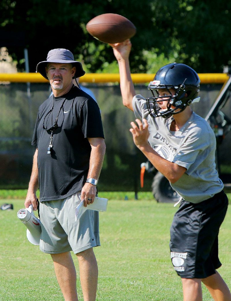 In this file photo Bauxite coach Daryl Patton watches as a middle school player throws during practice Monday morning on his school's baseball field.