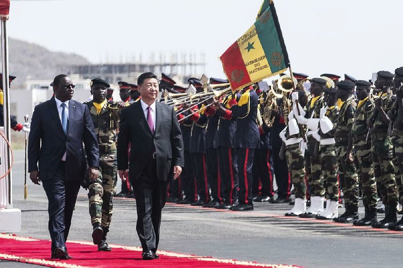 President Macky Sall (left) of Senegal and Chinese counterpart Xi Jinping inspect the honor guard Saturday as Xi makes a state visit to Senegal’s capital, Dakar.  