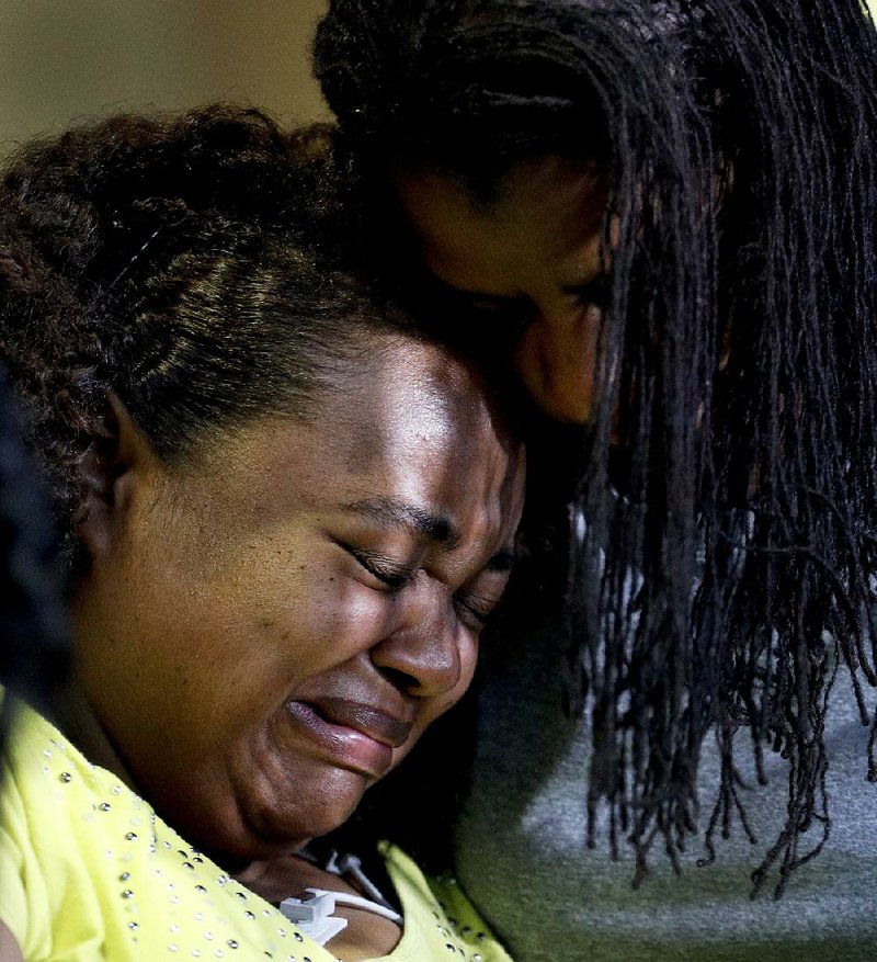 Tia Coleman, who lost nine family members when a duck boat sank Thursday night on Table Rock Lake, killing 17 people, recounted the ordeal Saturday from her hospital bed. Tia (left) is comforted Saturday by her sister, Leeta Bigbee, at Cox Medical Center in Branson after discussing the boat accident. 