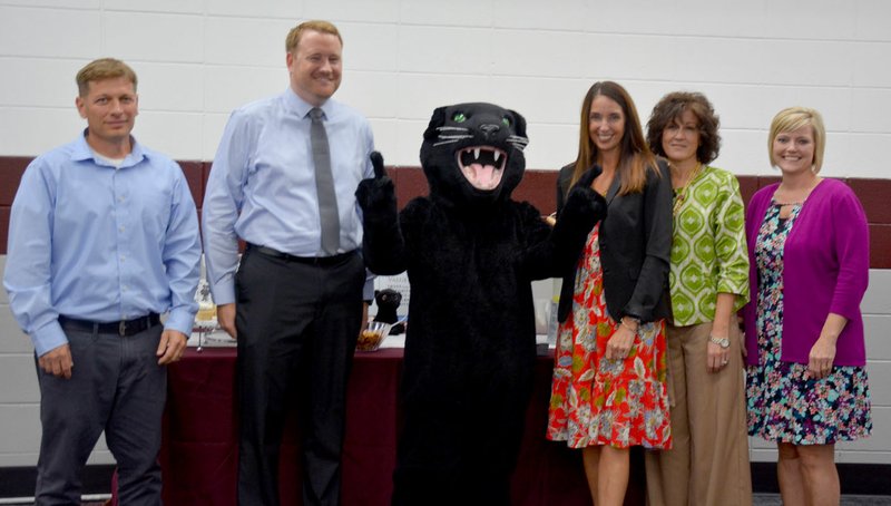 Hunter McFerrin/Siloam Sunday Toward the beginning of the meeting, the five new administrators that will begin their positions this school year pose for a photo opportunity with the Panther's mascot. Pictured (from left) is technology director Todd Cross, assistant high school principal Ross White, high school principal Ann Martfeld, Allen Elementary School assistant principal Victoria Groomer and Panther Health and Wellness Center Coordinator Krystal Wheat.