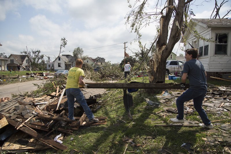 Clean up continues outside homes in Marshalltown, Iowa, on Saturday, July 21, 2018, two days after a devastating tornado blew through the city. The tornado here was among a flurry of unexpected twisters that swept through central Iowa on Thursday. (Kelsey Kremer/The Des Moines Register via AP)