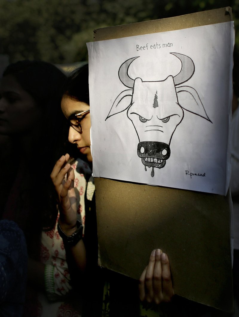 In this Oct. 2, 2015 file photo, a student activist holds a placard during a protest denouncing the killing of a 52-year-old Muslim farmer Mohammad Akhlaq by villagers upon hearing rumors that the family was eating beef in New Delhi, India. A Muslim man was beaten to death by a mob in western India over allegations of smuggling cows, police said Saturday, July 21, 2018, despite calls by the country's highest court for immediate steps to stop deadly mob violence across the country. (AP Photo/Altaf Qadri, File)