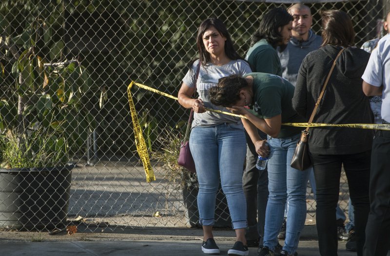 In this photo provided by Christian Monterrosa, a Trader Joe's employee bursts into tears after hearing news that a woman was shot and killed inside a Trader Joe's supermarket, Saturday, July 21, 2018, in Los Angeles. A gunman ran into the busy Los Angeles supermarket where he held dozens of people hostage Saturday before handcuffing himself and surrendering to police. (Christian Monterrosa via AP)