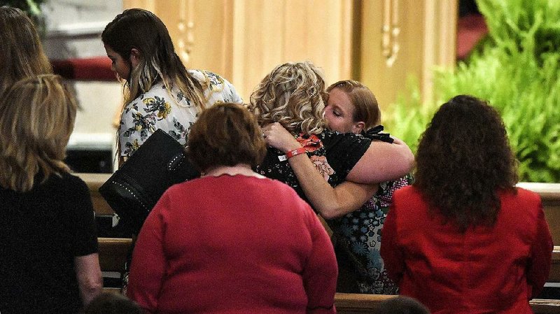 Family members of victims of the Branson duck boat sinking on Table Rock Lake embrace at the end of Sunday’s memorial service, at the Williams Memorial Chapel on the campus of the College of the Ozarks near Branson, on Sunday.  