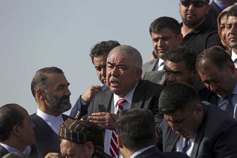 Afghan first vice president, a former Uzbek warlord, Gen. Abdul Rashid Dostum, center, and members of his entourage disembark on arrival at Kabul International Airport in Kabul, Afghanistan, Sunday, July 22, 2018.  (AP Photo/Rahmat Gul)