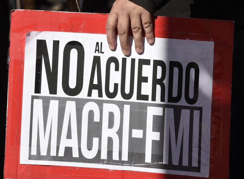 A protester holds a sign that reads in Spanish "No to the agreement Macri-IMF" during demonstration against International Monetary Fund near the G20 Finance Minister and Central Bank governors meeting in Buenos Aires, Argentina, Saturday, July 21, 2018. (AP Photo/Gustavo Garello)
