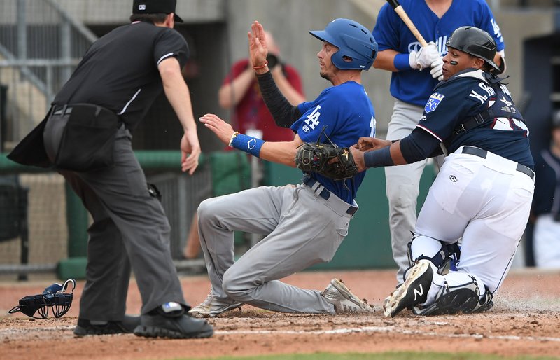 Northwest Arkansas’ Xavier Fernandez tags Tulsa’s Tyler Goeddel at home plate Sunday at Arvest Ballpark in Springdale. The Naturals won 5-2. 