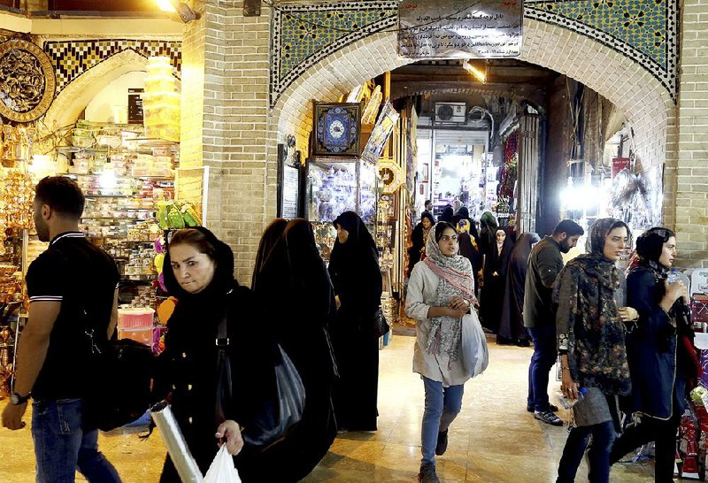 People walk at the old main bazaar in Tehran, Iran, on Monday. Iranians on Monday shrugged off the possibility that a bellicose exchange of words between President Donald Trump and his Iranian counterpart could escalate into military conflict, but expressed growing concern that America’s stepped-up sanctions could damage their fragile economy. 