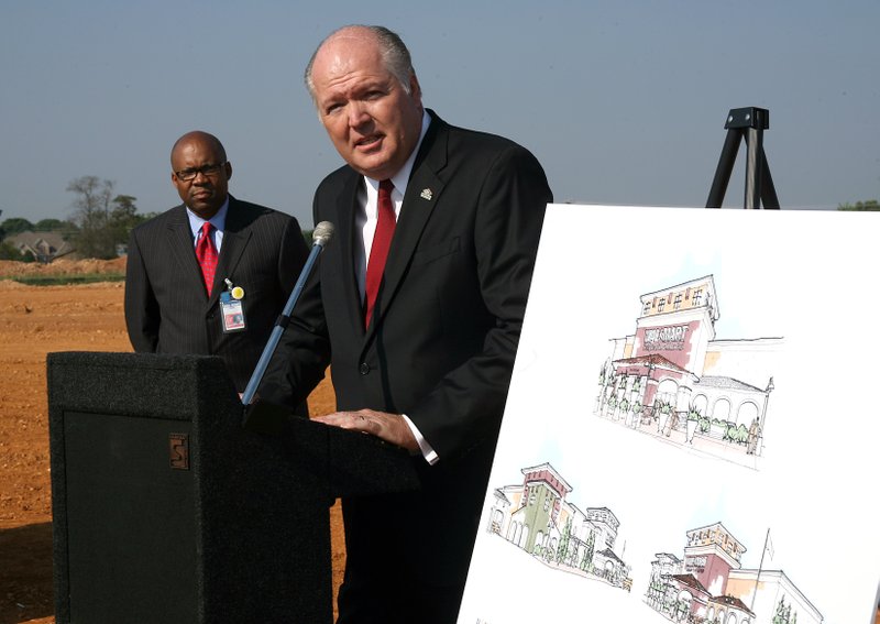 FILE — Don Frieson, senior vice President for the Central Division of Walmart (left) listens as Bill Schwyhart, partner in Pinnacle Investments, addresses an audience at the groundbreaking ceremony for the Walmart Neighborhood Market on Pinnacle Parkway in Rogers in this 2008 file photo.