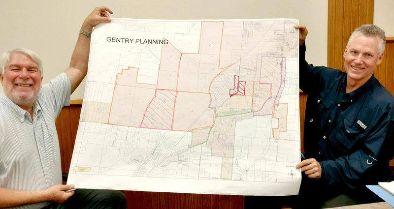 SUBMITTED Planning and zoning commission member Jim Kooistra and city attorney Jay Williams on Thursday hold a planning map with colors added to indicate suggested zoning changes for lands which have recently been annexed into the city. The commission has been working to make a recommendation to the council for zoning changes from the current agricultural zoning of annexed lands to zoning which best fits the lands' current and anticipated future uses.