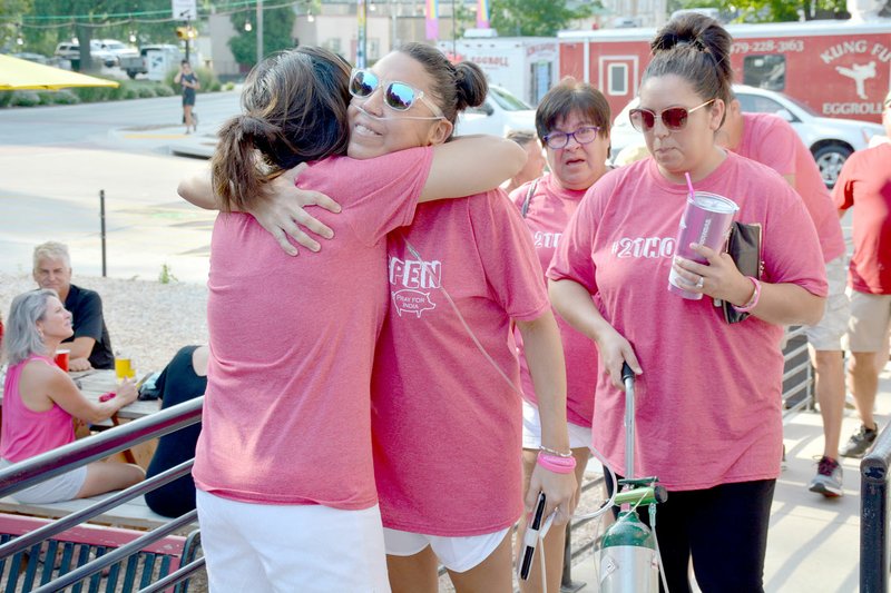 Graham Thomas/Herald-Leader Shawnda Free, left, hugs India Lewis on Friday at Creekside Taproom as Lewis and her family made their way into the back patio for an event welcoming Lewis back to Siloam Springs. Lewis has been in Tulsa the last several weeks receiving treatment for breast cancer.