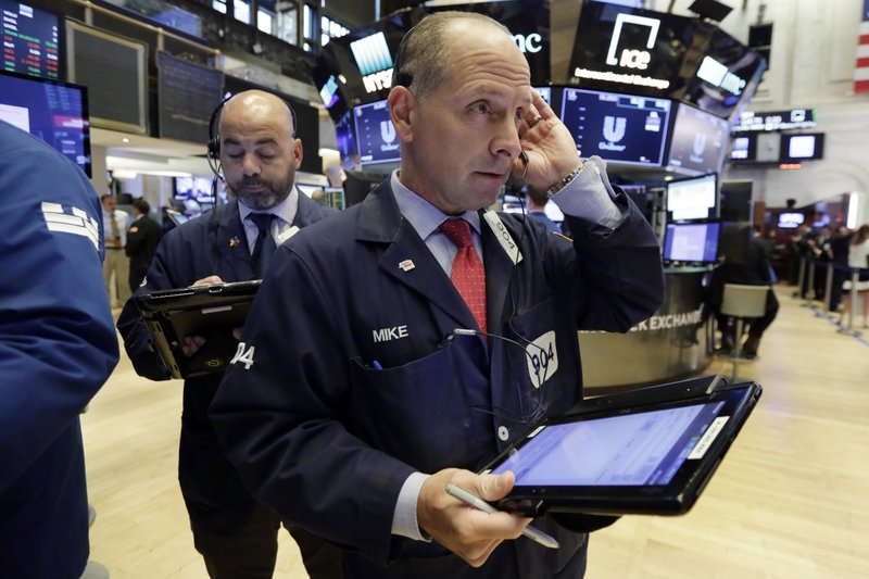 Traders Fred DeMarco, left, and Michael Urkonis work on the floor of the New York Stock Exchange, Tuesday, July 24, 2018. Stocks are opening broadly higher on Wall Street as investors were pleased to see strong earnings reports from a number of U.S. companies. (AP Photo/Richard Drew)