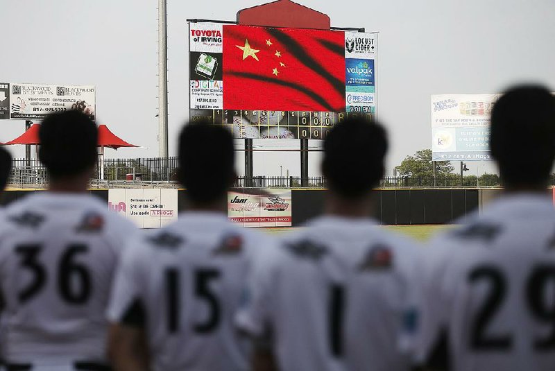 Texas AirHogs players stand for the Chinese national anthem in Grand Prairie, Texas. Chinese players are in the United States trying to improve for future international events.  
