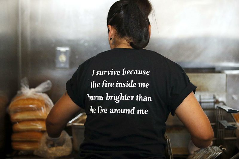 Yanet Rodriguez, 33, wears a T-shirt with words of encouragement while working at Homegirl Cafe.