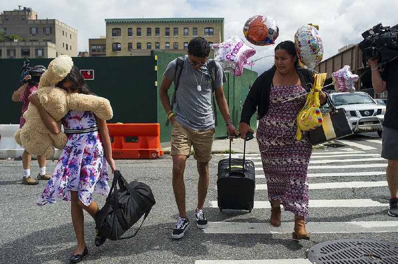  Carolina Ramos (right) leaves a nonprofit welfare agency Thursday in the East Harlem neighborhood of New York with her daughter and son. Ramos said they had been separated for 120 days. “I thank America that I am now with my children,” she said.