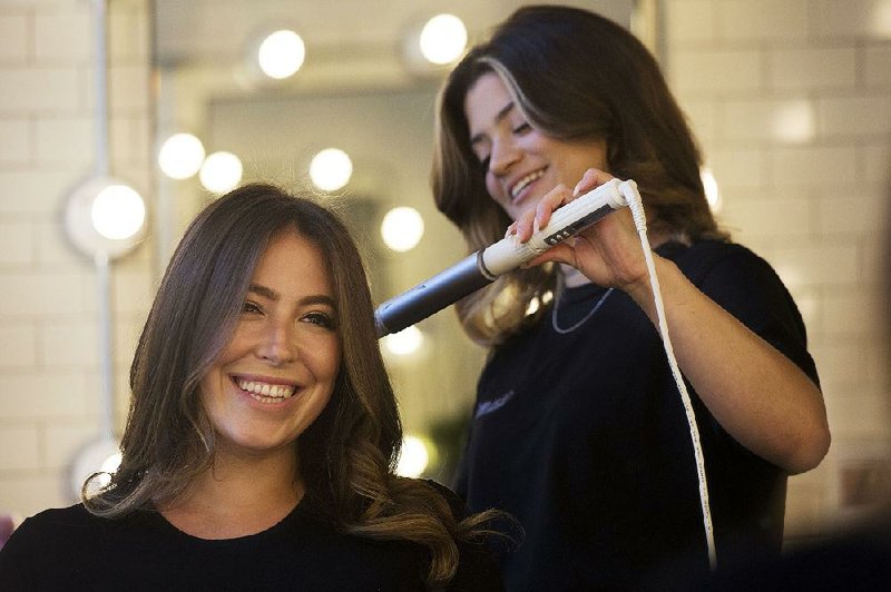 Hair salon owner Erika Wasser (left) has her hair touched up by lead hairdresser Samantha Shep- pard at Glam+Go earlier this month in New York.