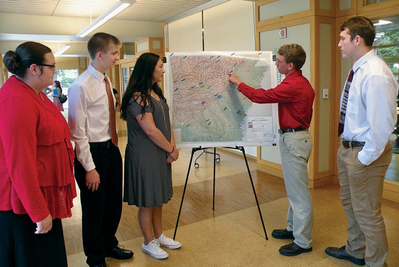 Kendall Townsley, second from right, points to one of the locations where early explorers traveled in Arkansas. His fellow students, from left, are RaLynnda March, Joe Hutchinson, Amelia Counts and Curt Jones. The five Cave City High School students recently prepared a documentary for the Butler Center for Arkansas Studies’ History Hub website for teachers. They are shown here as they prepare to present their project to a group of educators at a seminar in the Darragh Center of the Central Arkansas Library System’s main library in Little Rock.