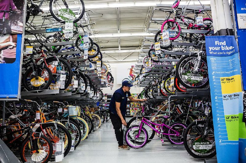 An employee arranges bicycles at a Walmart store in Secaucus, N.J. Walmart says its newly patented Listening to the Frontend device is a “concept” that would help gather metrics to improve the checkout process.  