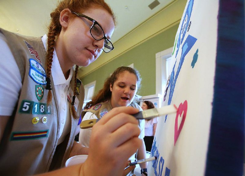 Girl Scouts Keaira Davis (left), 17, and Clair Williams, 16, of Mountain Home work on a collaborative painting as part of the #ARGIRLSLEAD project during the kickoff event for the Women’s Suffrage Centennial Commemoration Committee on Saturday in Little Rock.  
