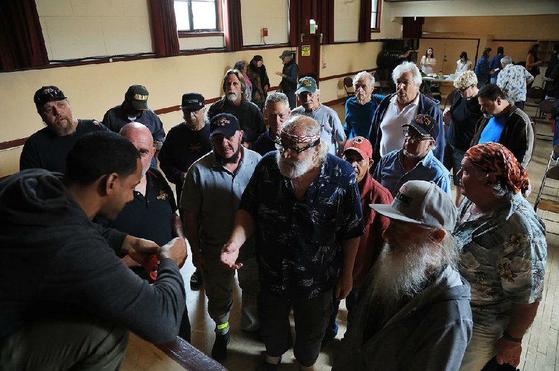 A member of the Santa Cruz Veterans Alliance hands out tickets to veterans, which they can exchange for medical marijuana, after a monthly meeting July 2 in the California town. 
