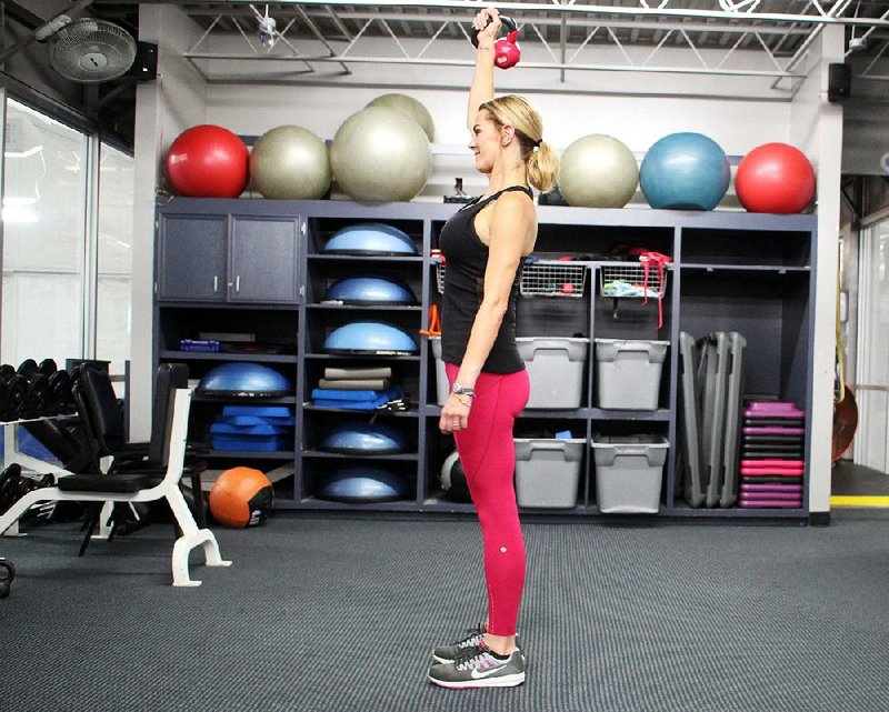 Ashley Bermingham holds her kettlebell like Lady Liberty holding up her flame, and she watches that her knees don’t bend too much while lunging forward and back while doing the Liberty Kettlebell. Part 1.