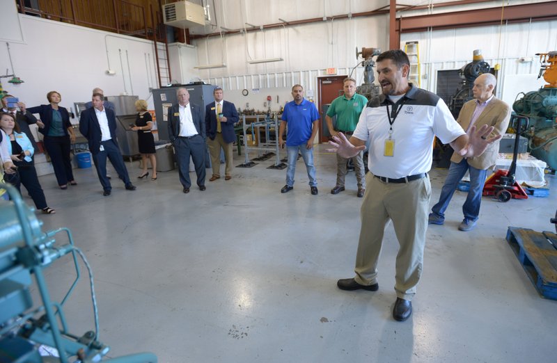 David Rook, associate director of refrigeration training for Tyson Foods, leads a tour Wednesday of the Northwest Technical Institute’s ammonia refrigeration program during an announcement of a planned $3 million expansion for the program.