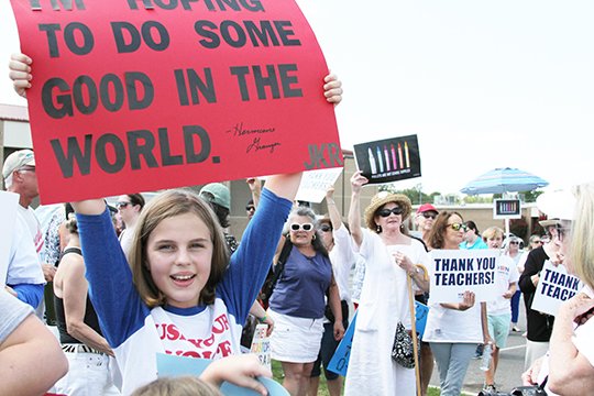 The Sentinel-Record/Rebekah Hedges SIGN OF PROTEST: Ten-year-old Clara McCarley, of Hot Springs, holds a sign outside of Lake Hamilton High School in protest of guns in schools on Wednesday.