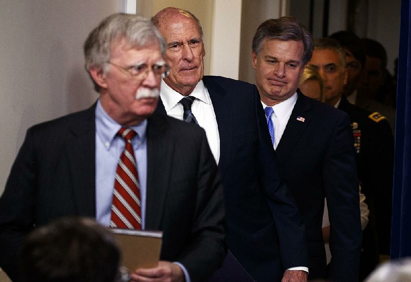 White House national security adviser John Bolton (from left), Director of National Intelligence Dan Coats and FBI Director Christopher Wray arrive Thursday for a briefing at the White House. 